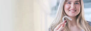 woman holding clear aligner